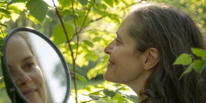 Woman smiling in the mirror at her 3 month before and after results from PRP for hair loss.