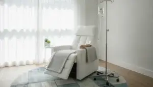 Modern IV therapy treatment room with comfortable reclining chair and IV drip setup